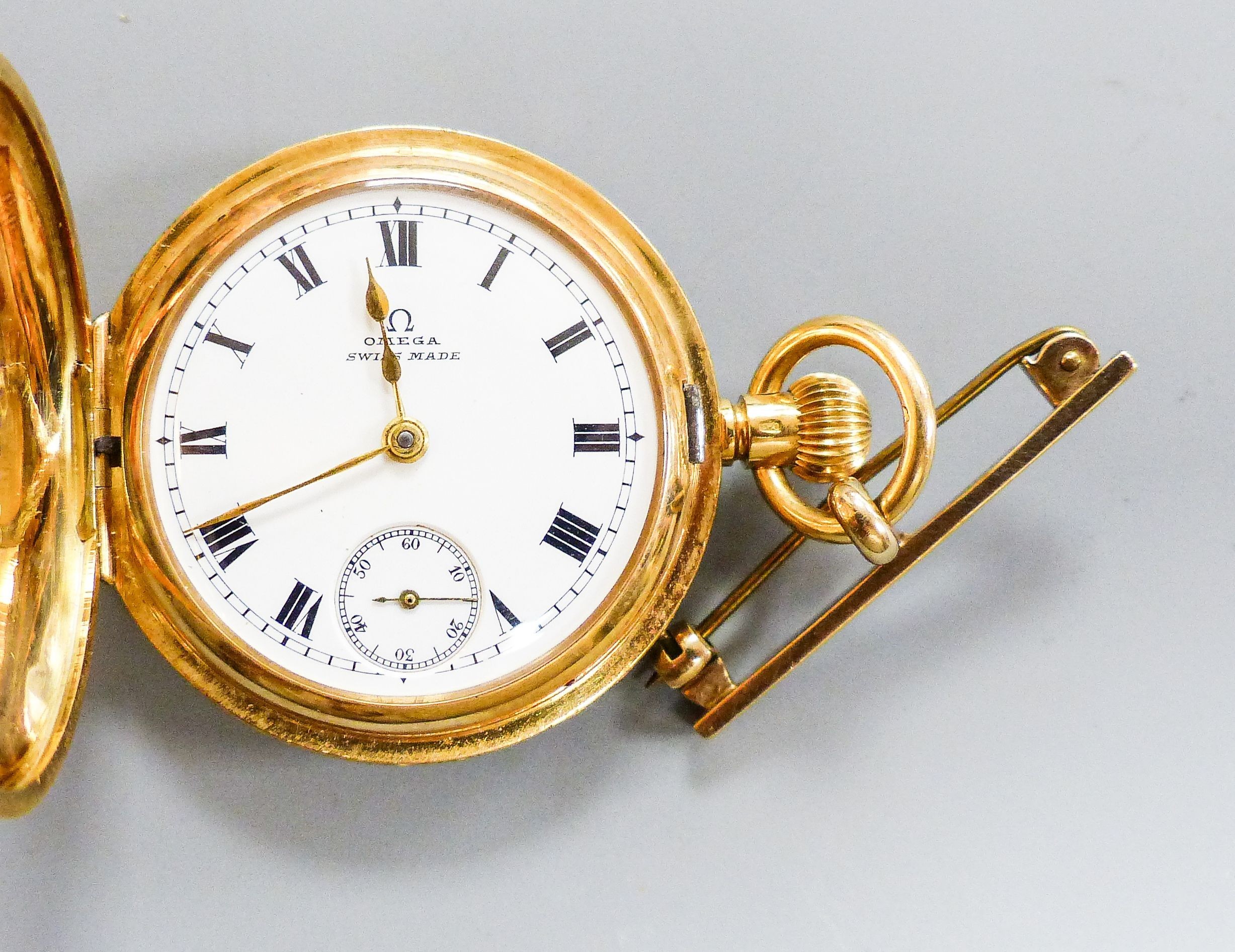 An engraved 18k Omega half hunter fob watch, cased diameter, 34mm, with a 9ct gold suspension brooch